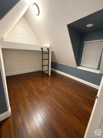 Hardwood flooring, built-in loft bed with a ladder, recessed lighting, and a window with blinds