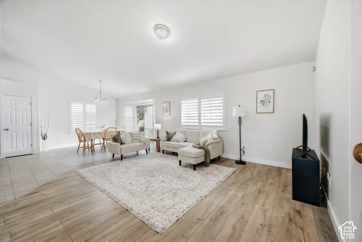 Vaulted ceilings accent the living area with wood-finish flooring, complemented by tile flooring in the dining space