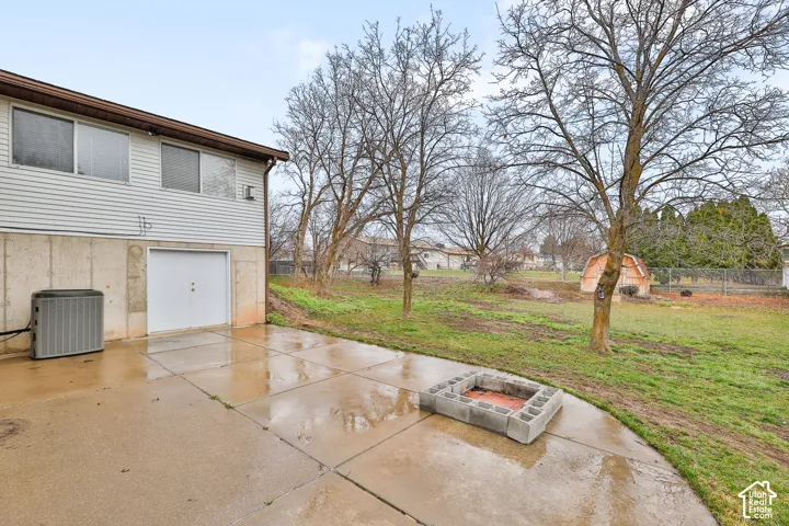 Concrete patio featuring a block fire pit