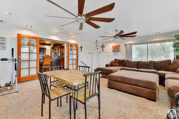 Spacious room featuring multiple ceiling fans, recessed lighting, and a large window