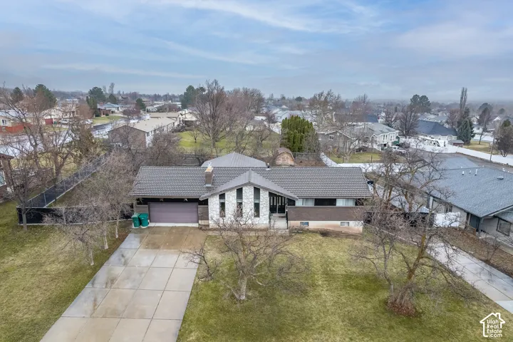Architectural siding with stone accents, attached two-car garage, concrete driveway, and mature landscaping