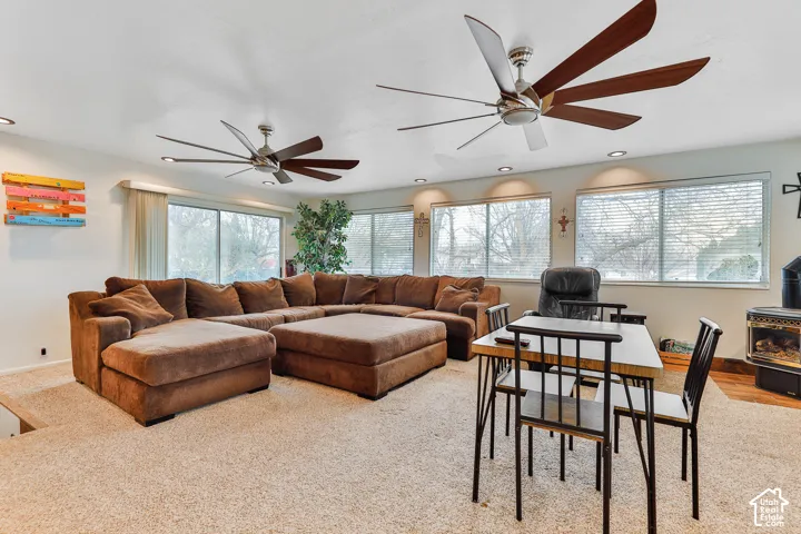 Recessed lighting and two large ceiling fans illuminate this space with multiple windows