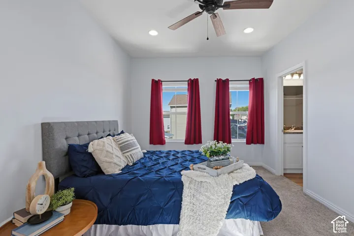 Sunny primary bedroom features large windows, a ceiling fan and an ensuite bathroom