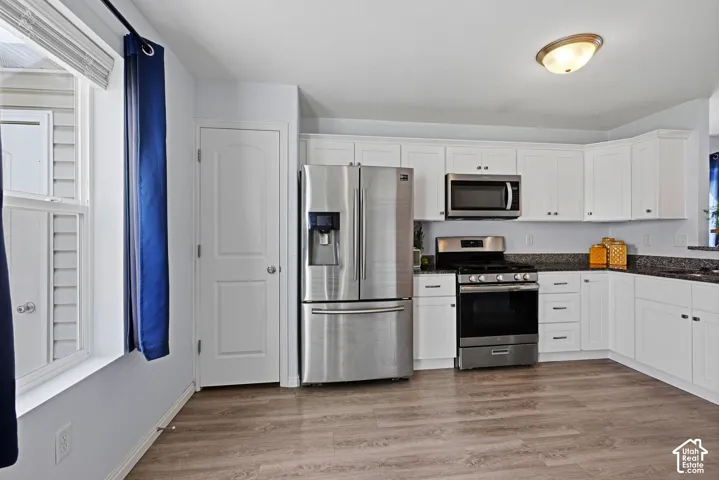 The kitchen offers stainless steel appliances, white shaker cabinetry and floor to ceiling pantry