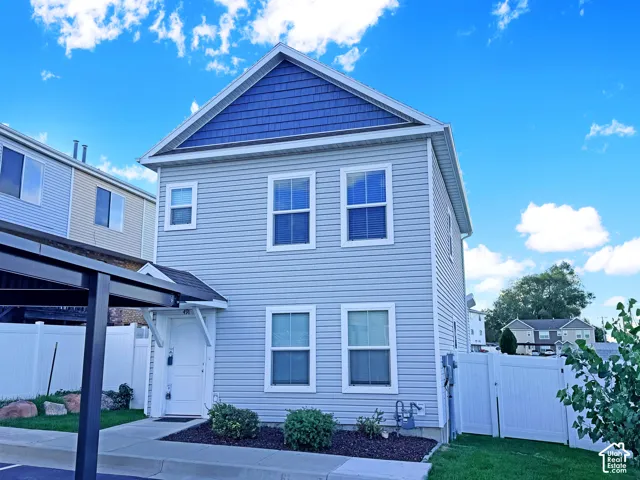Two-story residence featuring light blue siding with contrasting blue shakes on the gable