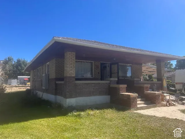 Brick exterior featuring a covered front porch and concrete steps