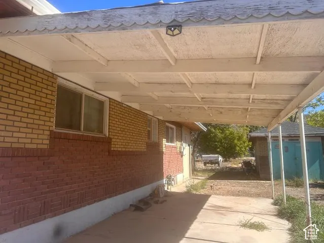 Brick exterior with two-tone masonry, covered patio, and attached carport