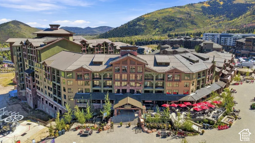 Multi-story building featuring extensive window-lines, tiered balconies, and a durable metal roof