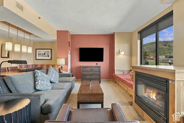 Built-in fireplace with a hearth, expansive window with mountain scenery, built-in window seating, recessed lighting, and an overhead lighting fixture with four pendants