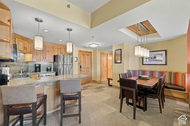 Kitchen with wood cabinetry, stainless steel appliances, and a breakfast bar