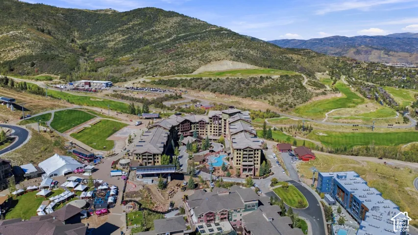 Expansive mountain landscape with multiple residential buildings, a central pool, and surrounding green spaces