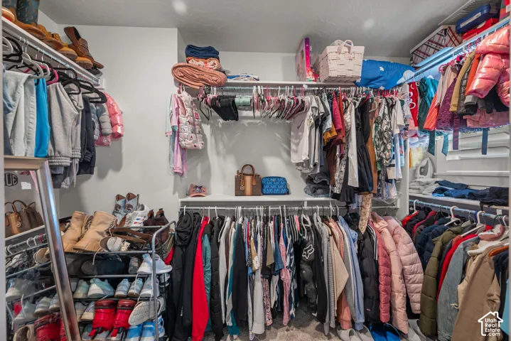 Integrated closet organization system featuring multiple hanging rods and overhead shelving