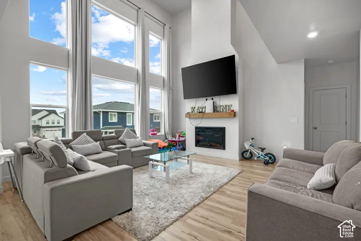 Two-story windows, recessed lighting, wood-finish flooring, built-in fireplace, and a wood mantel