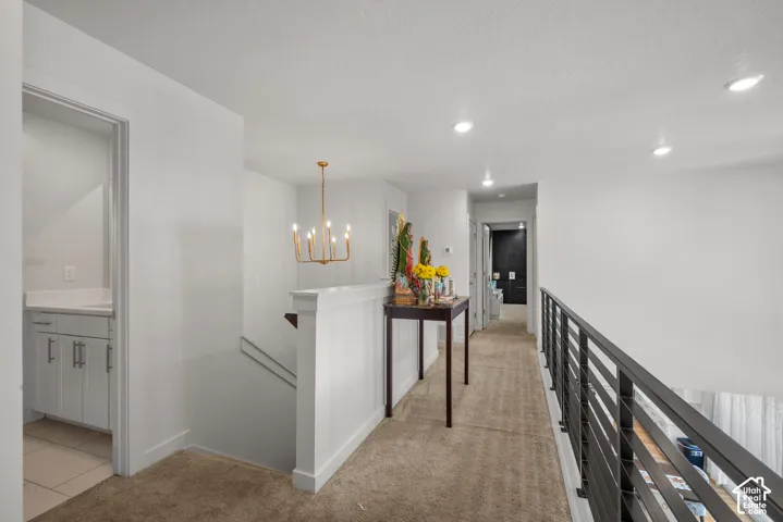 Recessed lighting, gold-tone chandelier, and modern metal railing