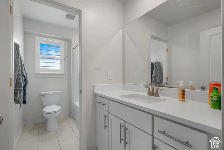 White vanity with a solid surface countertop, undermount sink, and brushed nickel faucet