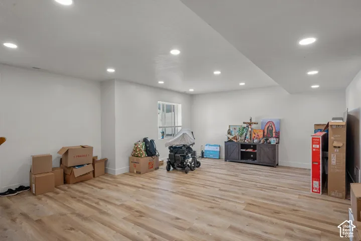 Recessed ceiling lighting, wood-finish flooring, white walls, and a window