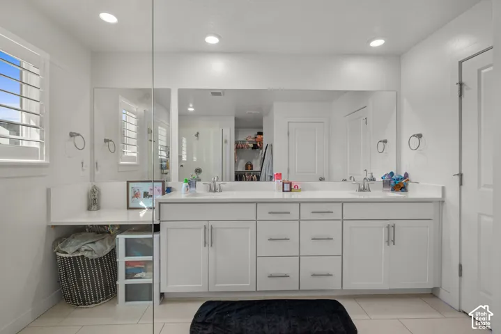 Dual sink vanity with white cabinetry and integrated countertops