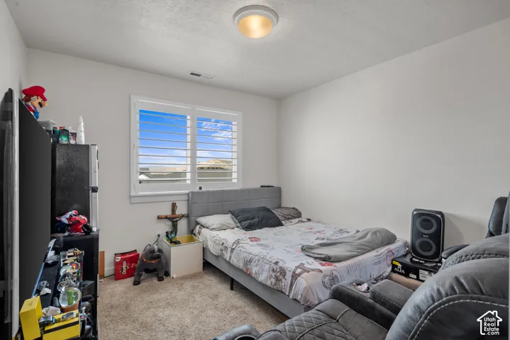 Recessed window with white plantation shutters, neutral tone walls, and carpet flooring