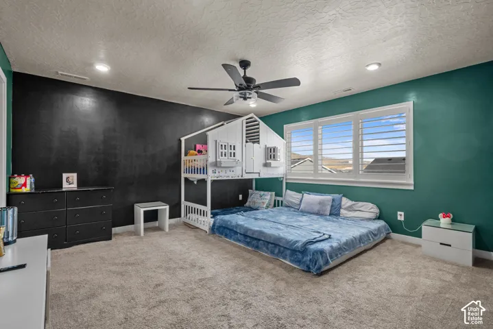 Recessed lighting, ceiling fan, window with louvered shutters, and carpeted flooring