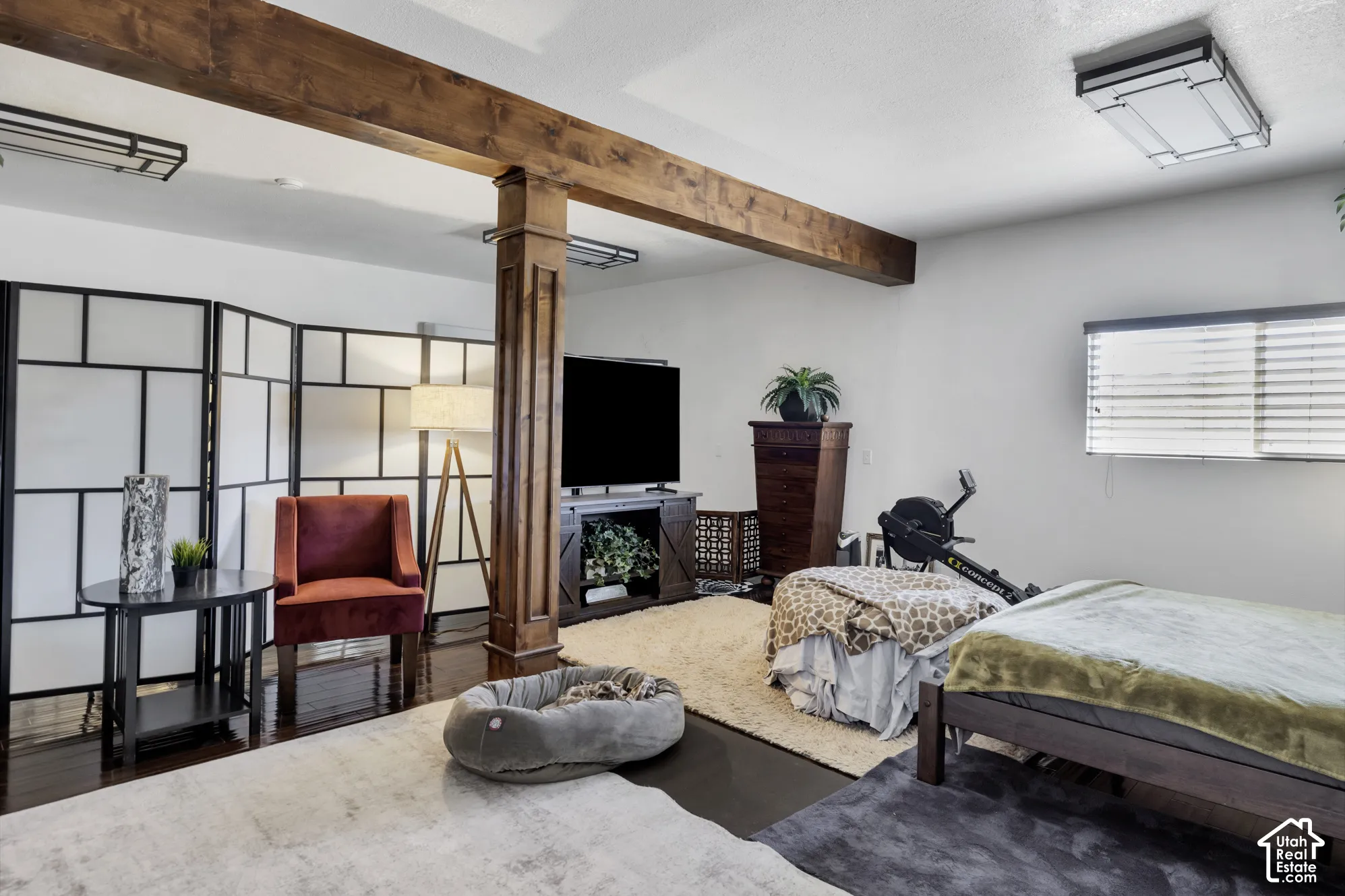 Exposed wood beam ceiling accents, dark wood-finish flooring, recessed lighting, and a window with blinds
