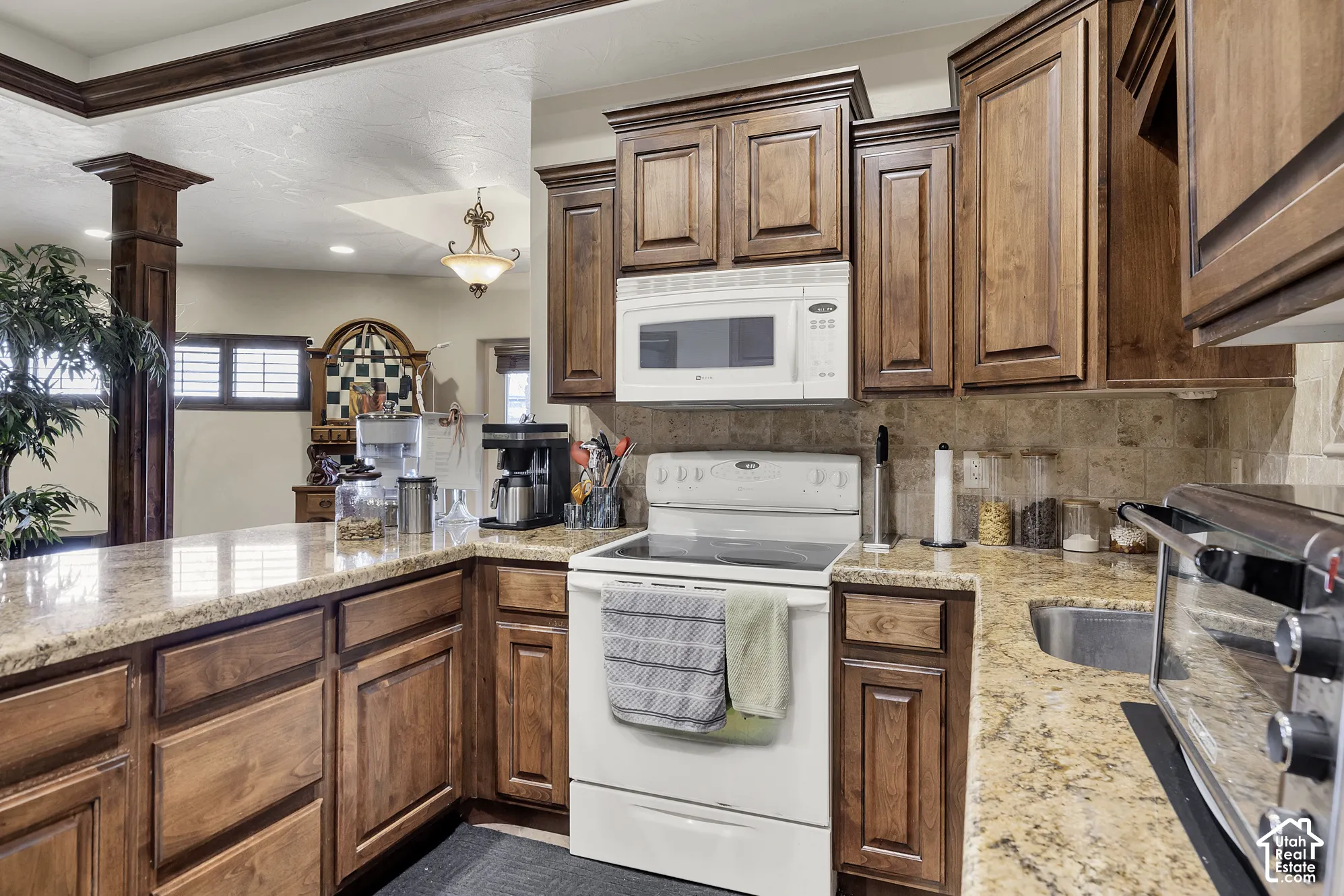 Wood-finish cabinetry paired with granite-style countertops and a tile backsplash