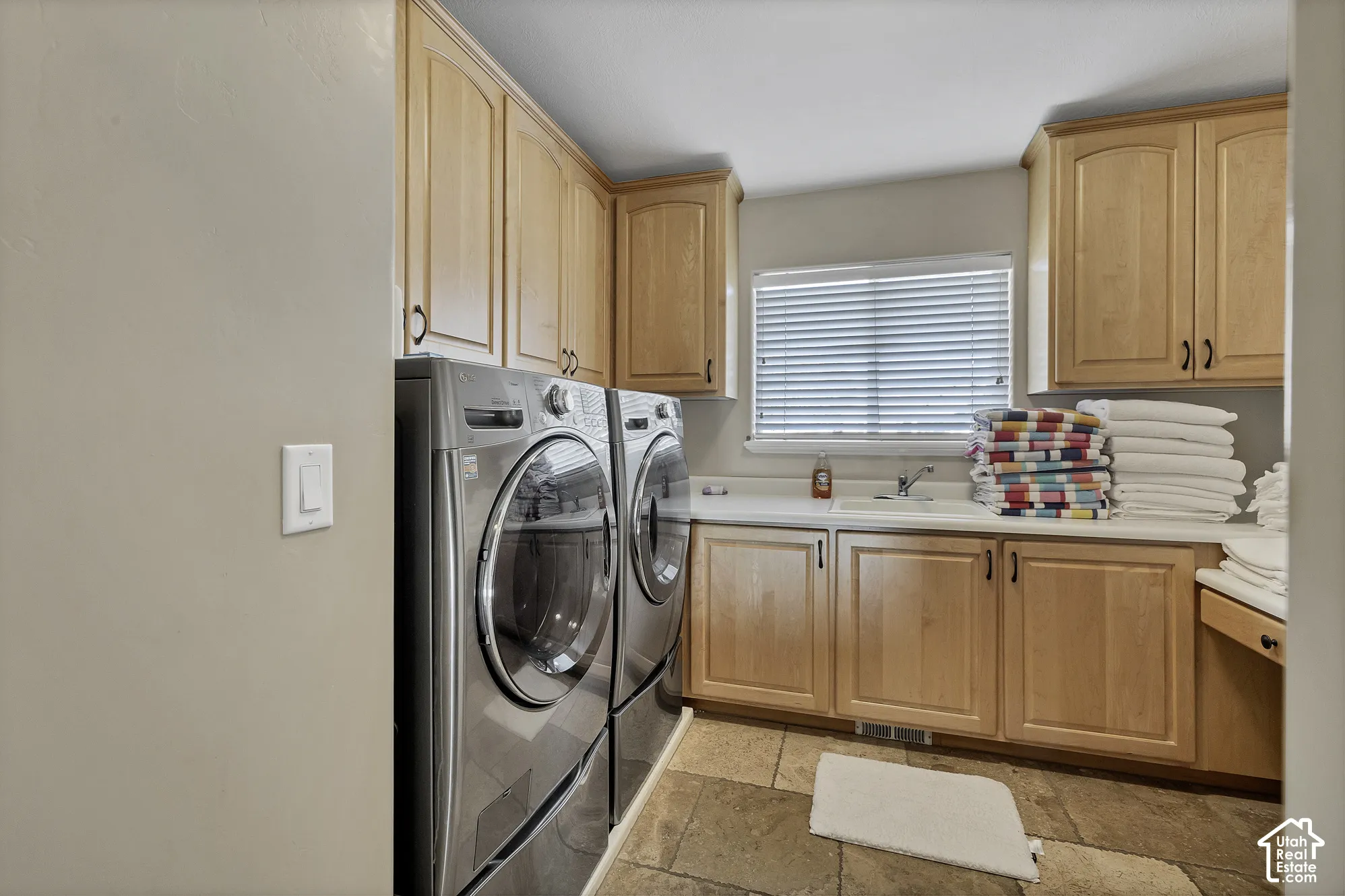 Wood cabinetry, white countertop, integrated sink, and tiled flooring