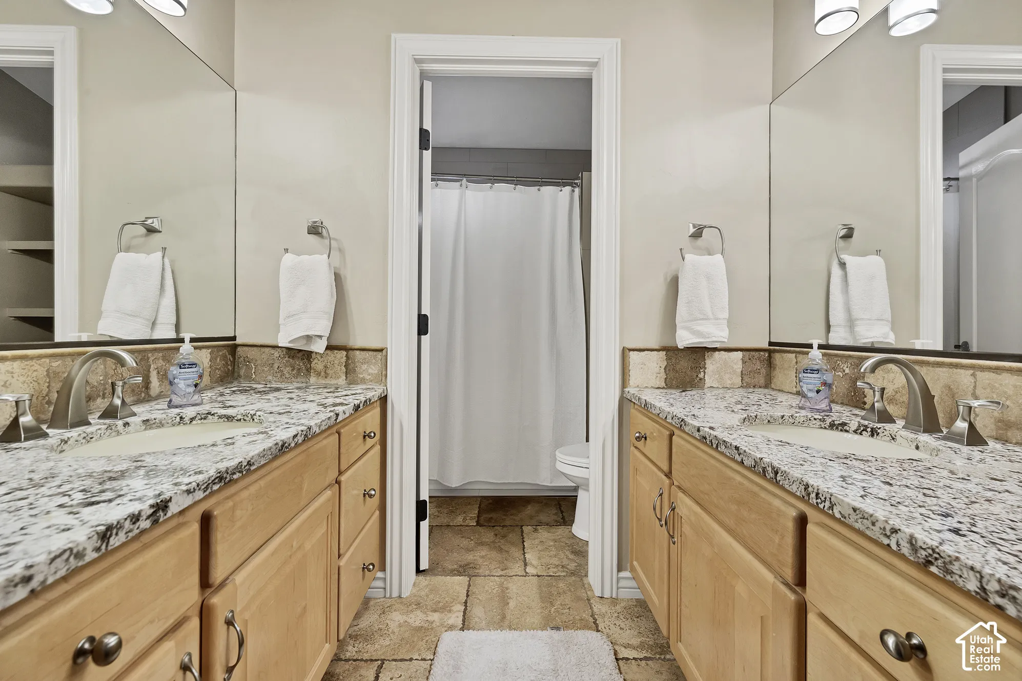 Dual vanities with integrated sinks, granite countertops, and brushed nickel fixtures