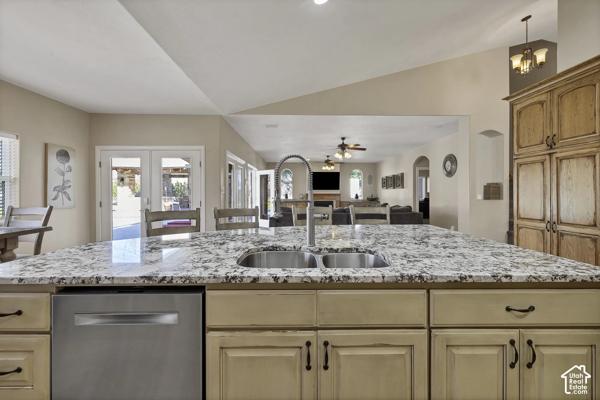 Kitchen island with a dual basin sink, pull-down faucet, and granite-style countertop