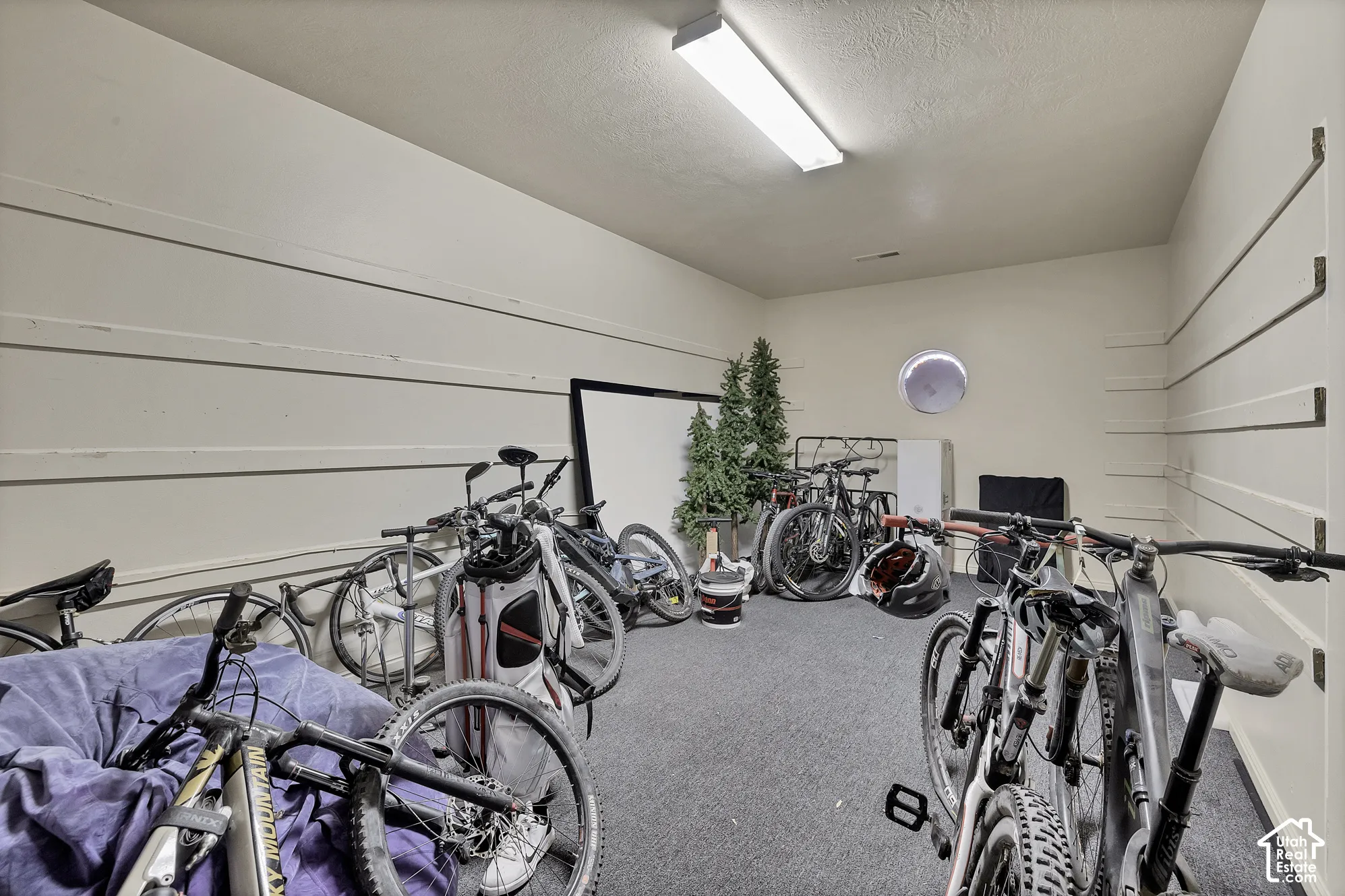 Wall-mounted shelving system, overhead fluorescent lighting, and a circular wall vent