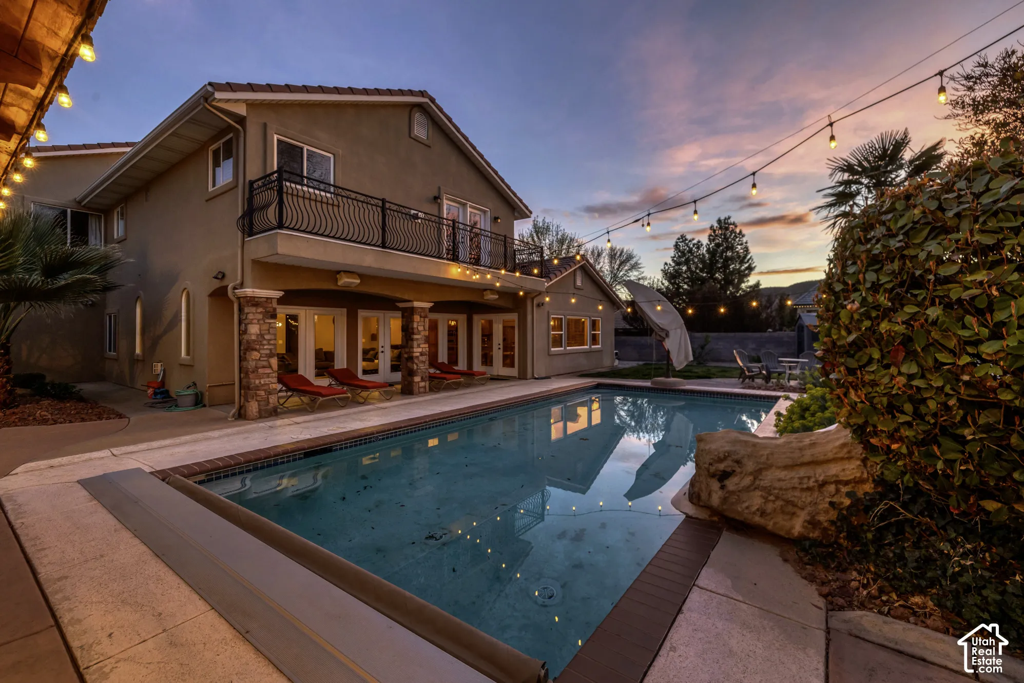 Expansive swimming pool with a stone coping, surrounded by a concrete patio