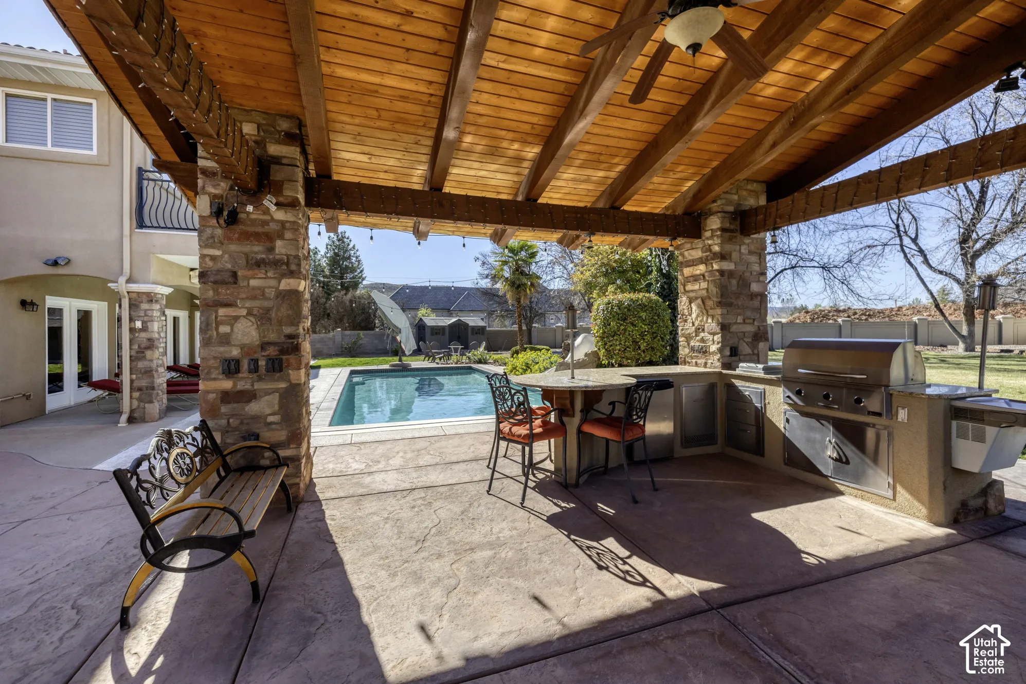 Outdoor kitchen featuring a built-in grill, bar seating, and stone accents