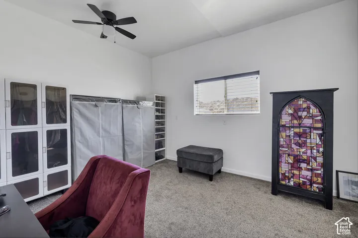 Ceiling fan with integrated lighting, carpeted flooring, and a single window with blinds