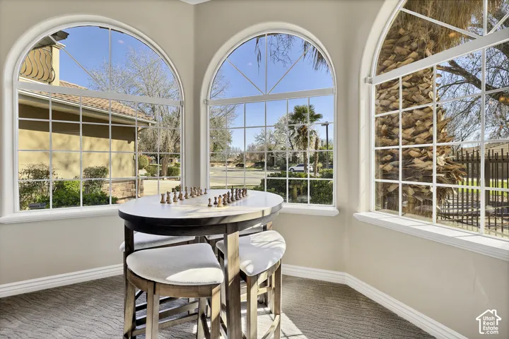 Multiple arched windows with grid patterns, light-colored walls, and textured carpet flooring