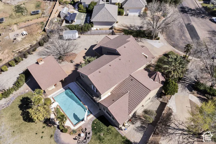 Expansive property featuring a swimming pool, detached accessory structure, paved patios, and mature landscaping