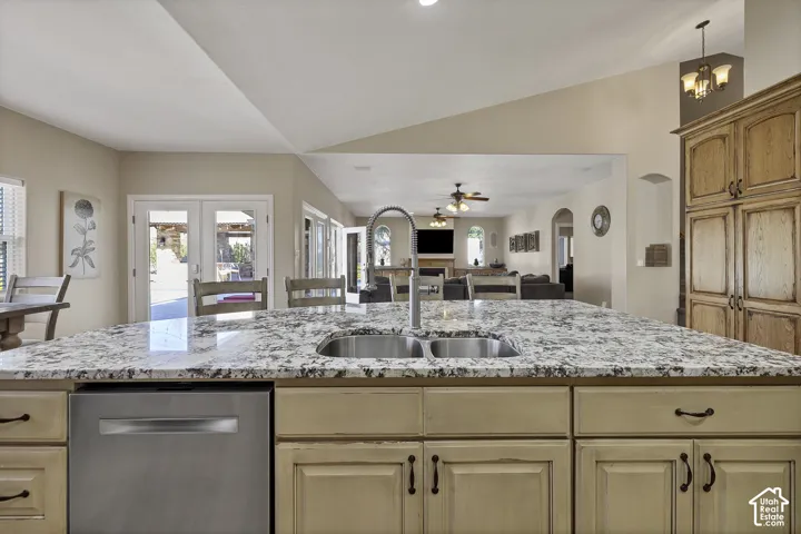 Kitchen island with a dual basin sink, pull-down faucet, and granite-style countertop