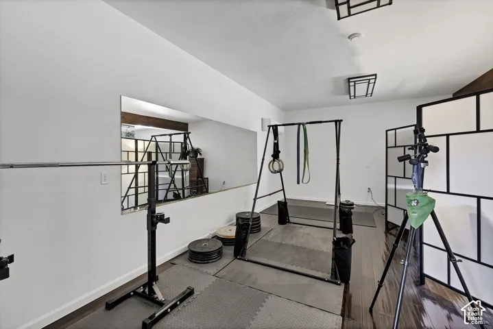 White painted walls with a large built-in mirror, wood-finish flooring, and recessed ceiling lighting