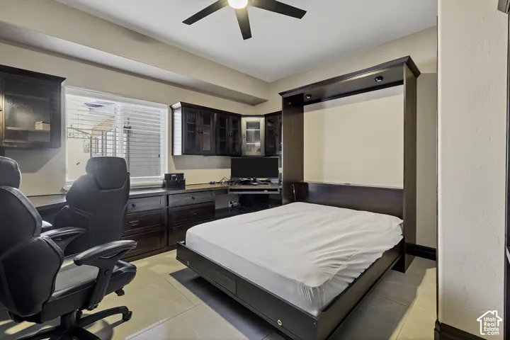 Built-in desk with dark wood cabinetry, integrated lighting, and a window with blinds