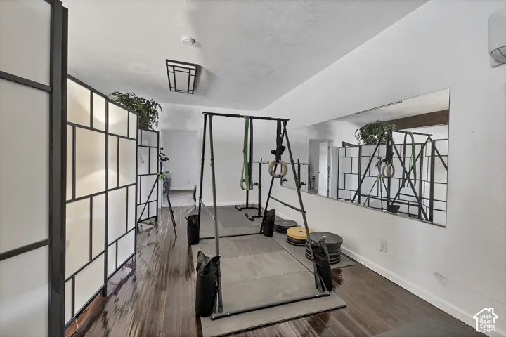 Wood-finish flooring, white walls, built-in wall mirror, geometric room divider, recessed ceiling light fixture