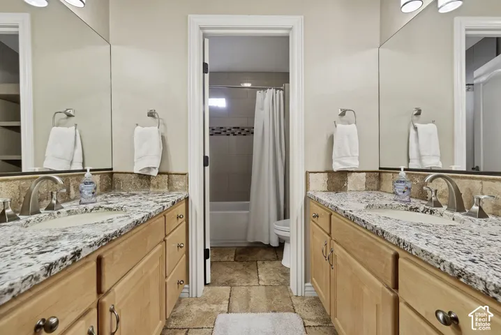 Dual vanities with stone countertops, undermount sinks, and brushed nickel fixtures