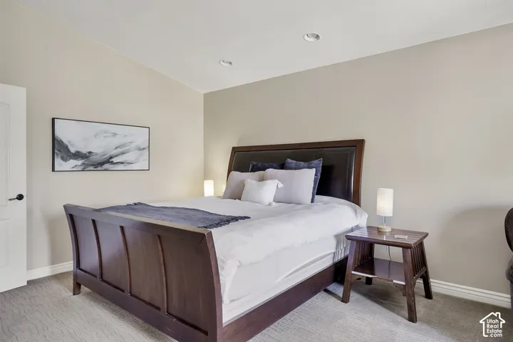 Neutral wall paint, recessed lighting, and textured carpeting