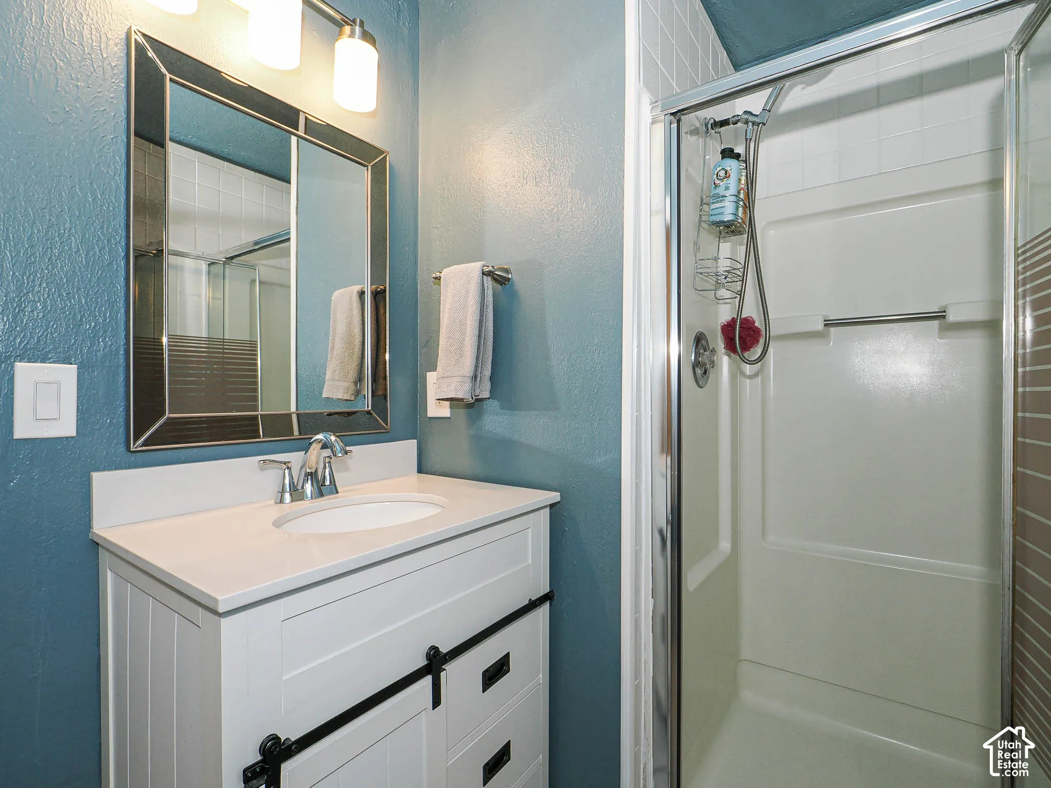White vanity with a single basin sink, chrome faucet, and integrated countertop