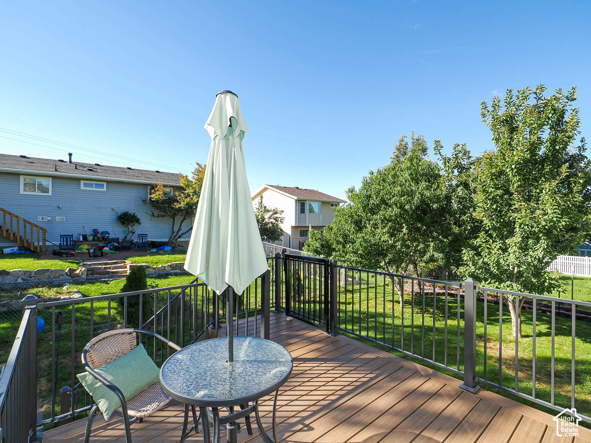 Outdoor deck featuring composite decking, black metal railing, and a gate