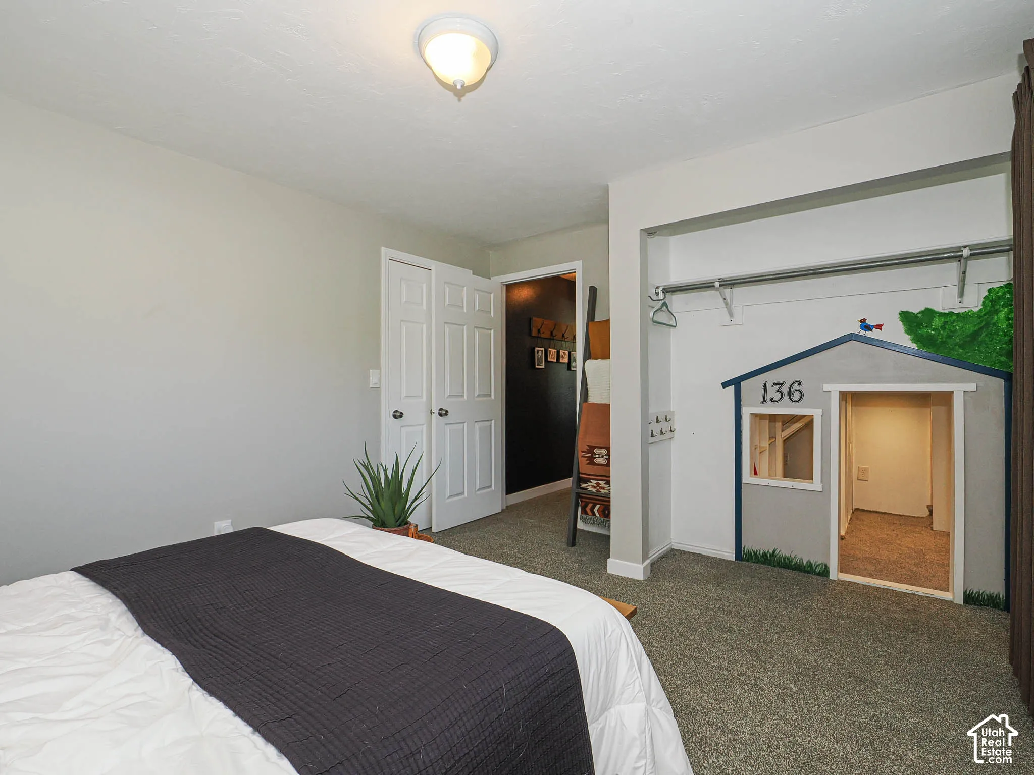 Wall-to-wall carpeting, overhead flush mount lighting, custom built-in playhouse structure, and bi-fold closet doors