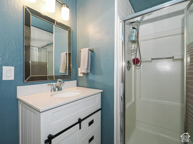White vanity with a single basin sink, chrome faucet, and integrated countertop