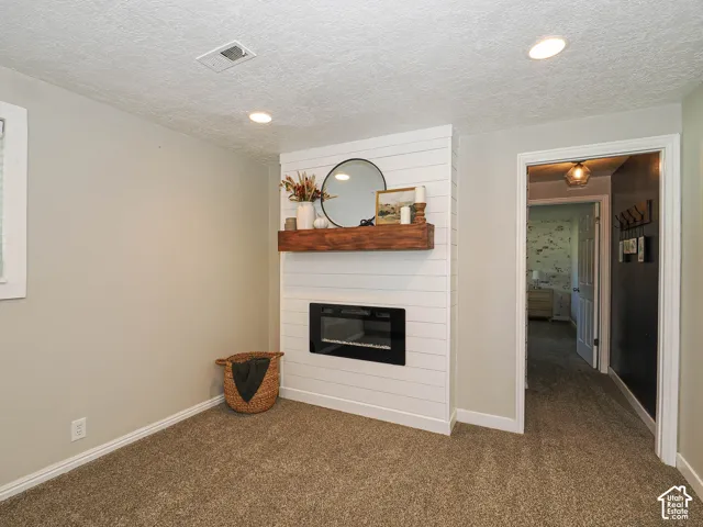 Integrated electric fireplace featuring a wood mantel and shiplap surround