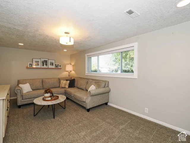 Recessed lighting complemented by a central flush-mount fixture, neutral paint throughout, and a window with white trim