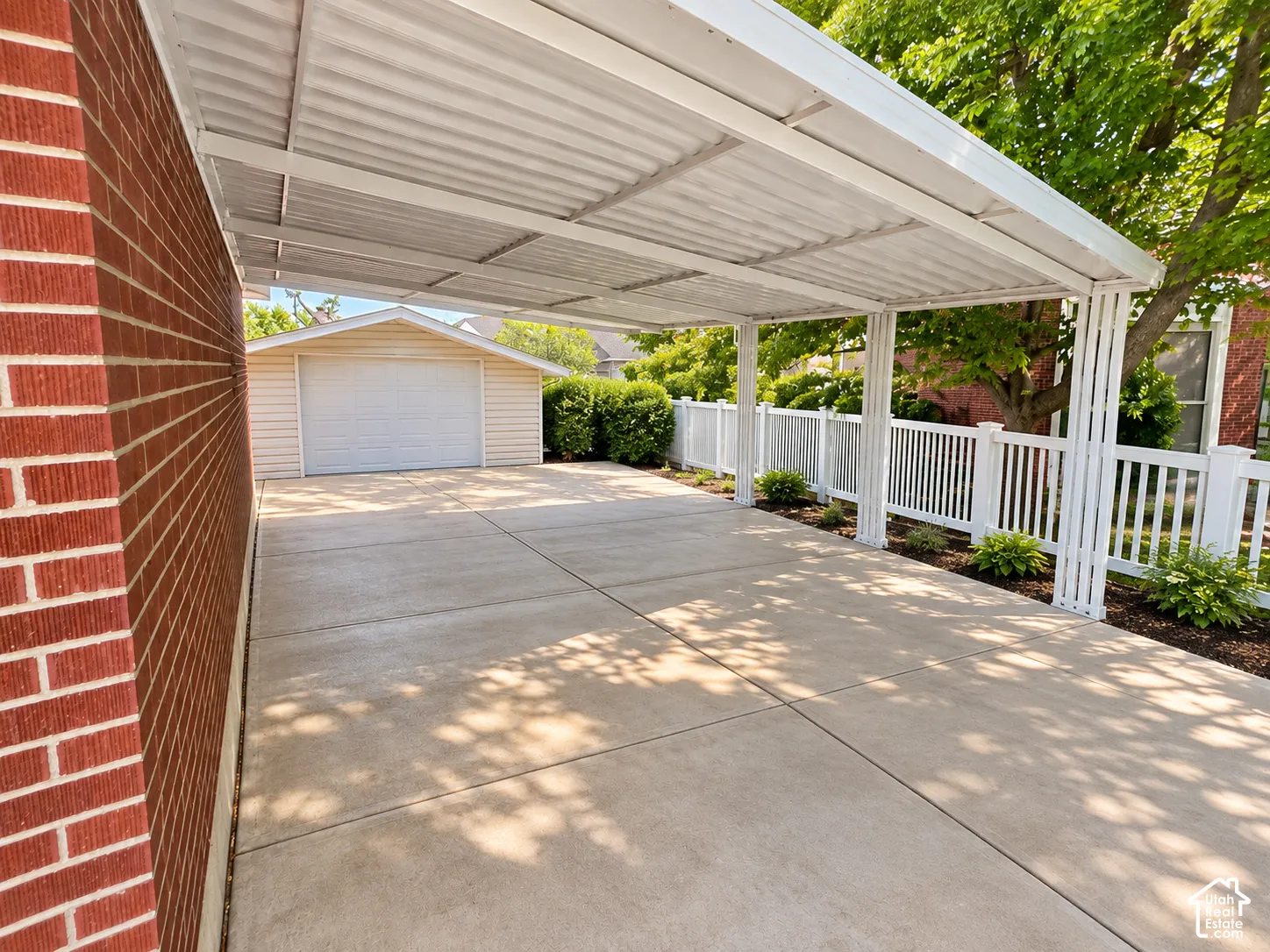 Covered carport with white metal roofing and support columns