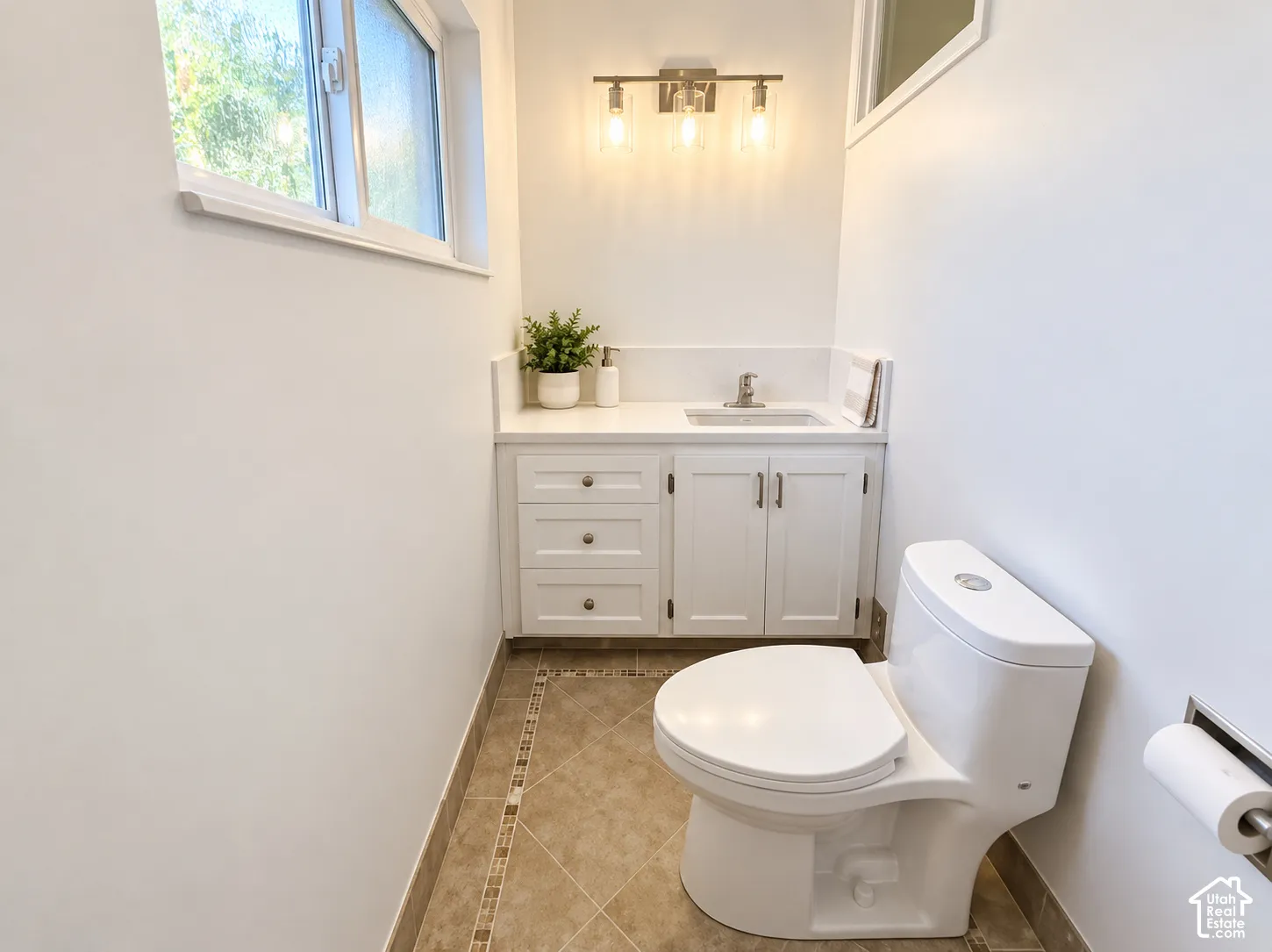 Primary bath with White vanity with a solid surface countertop, undermount sink, and brushed nickel faucet