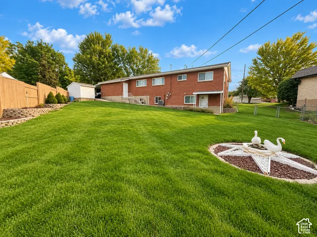 Expansive grassy yard with a stepped retaining wall and wood fencing