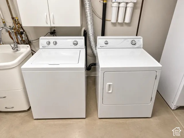 Laundry area featuring a top-load washing machine, front-load dryer, and utility sink